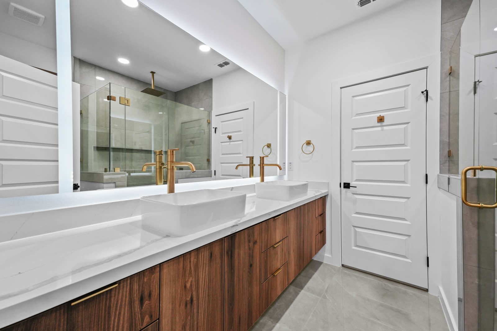 Interior entregado: baño principal con grifería dorada y doble lavabo