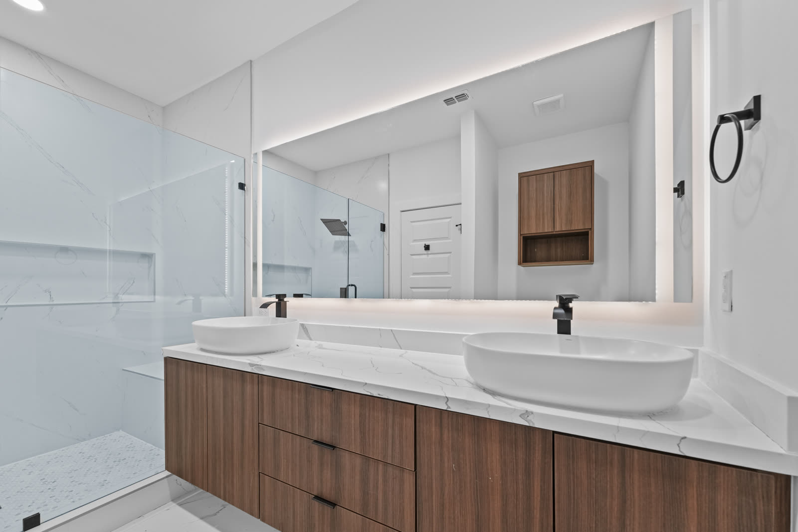 Interior entregado: baño principal con doble lavabo sobre cubierta marmoleada