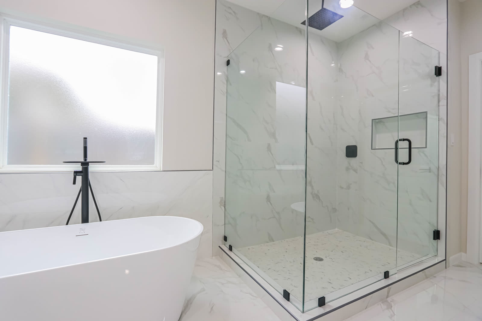 Interior entregado: baño con tina exenta y regadera de cristal a piso