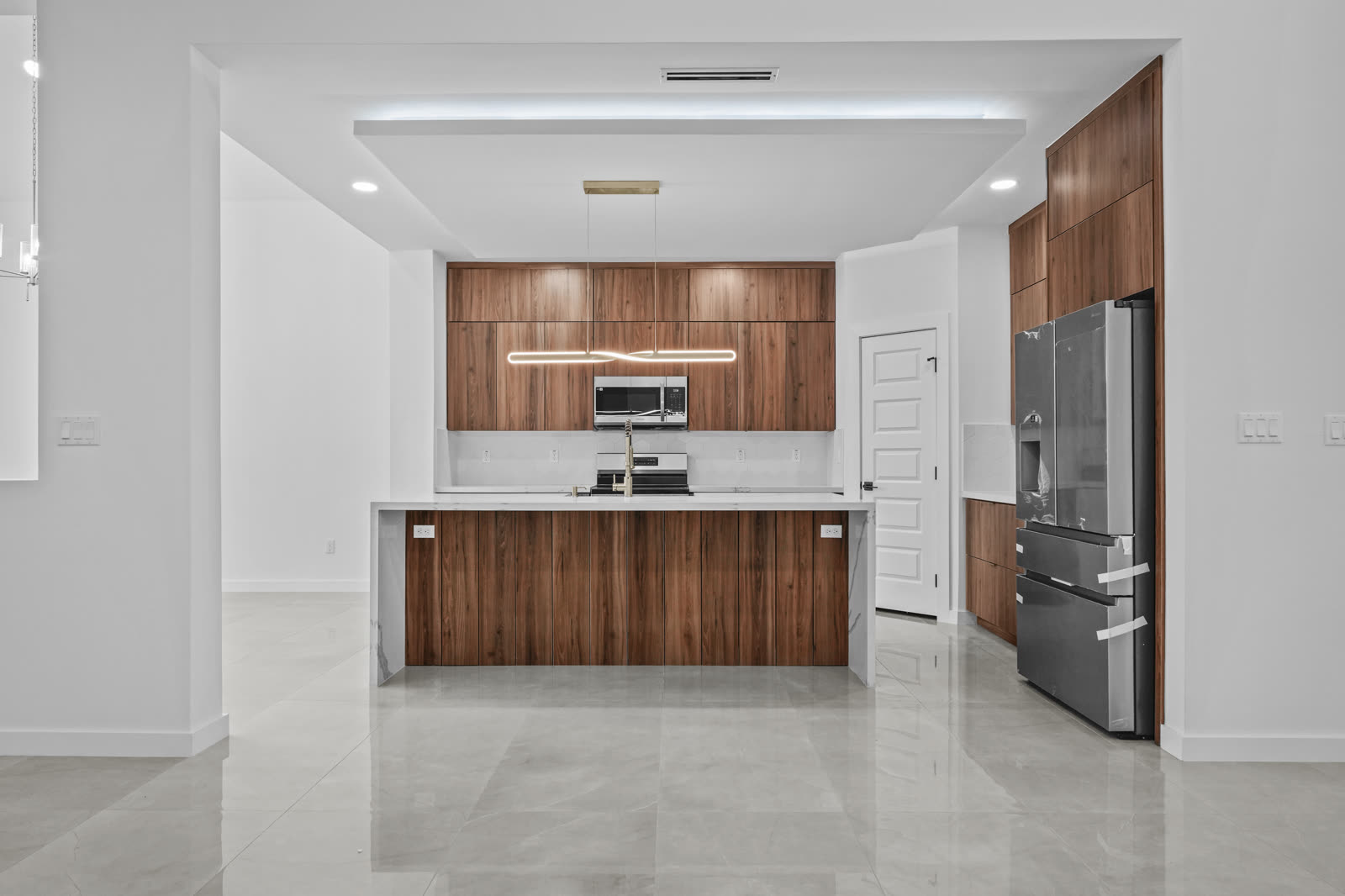 Interior entregado: cocina de nogal con isla y cubierta marmoleada