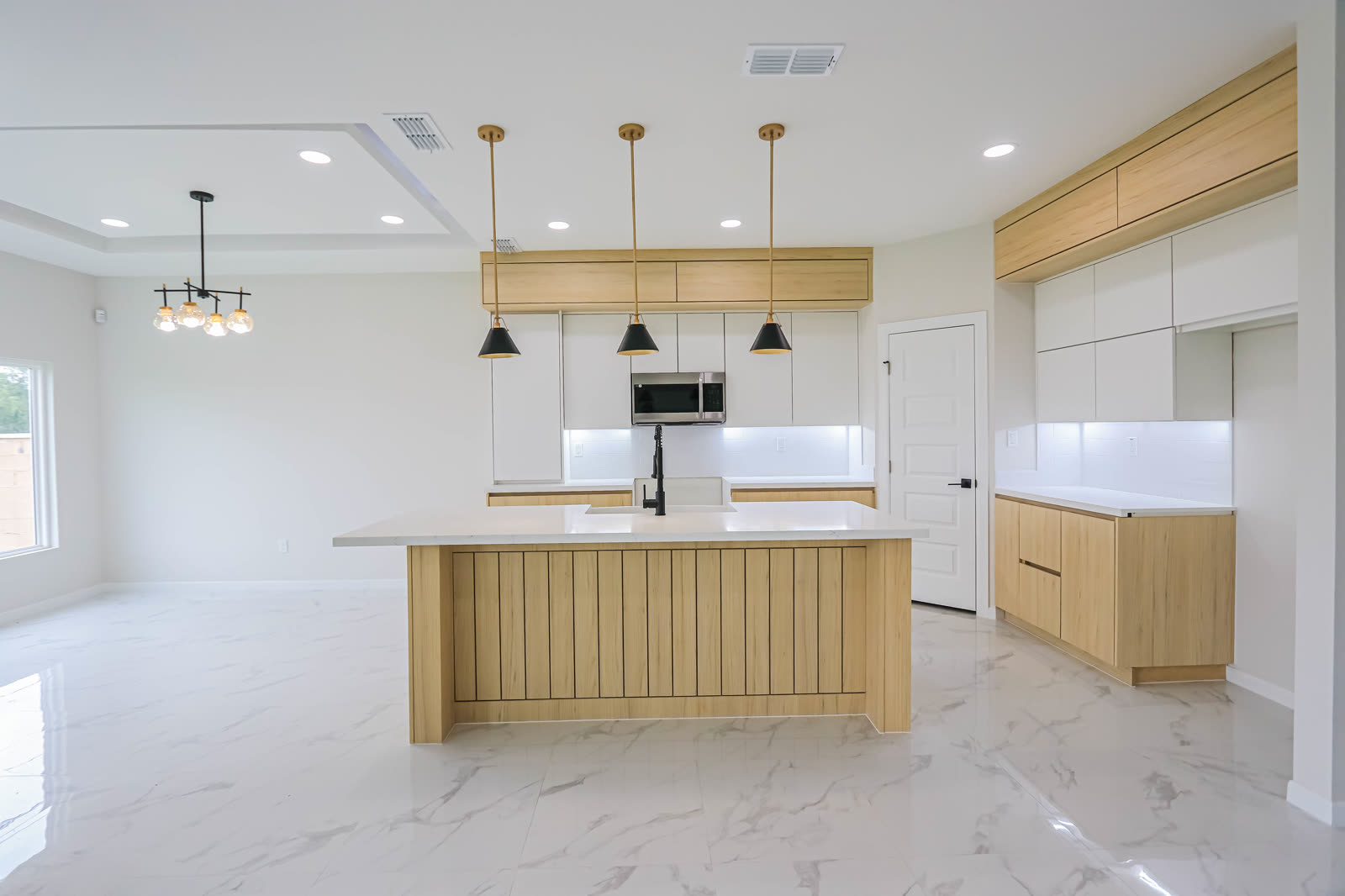 Interior entregado: cocina de roble claro con isla ranurada y comedor contiguo