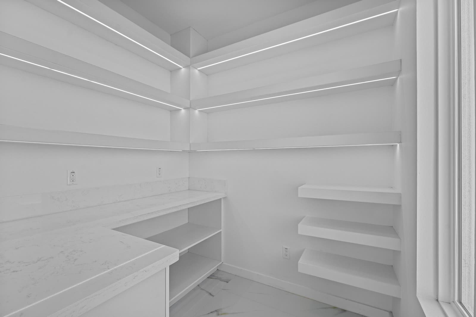 Interior entregado: despensa con entrepaños iluminados y barra de cuarzo